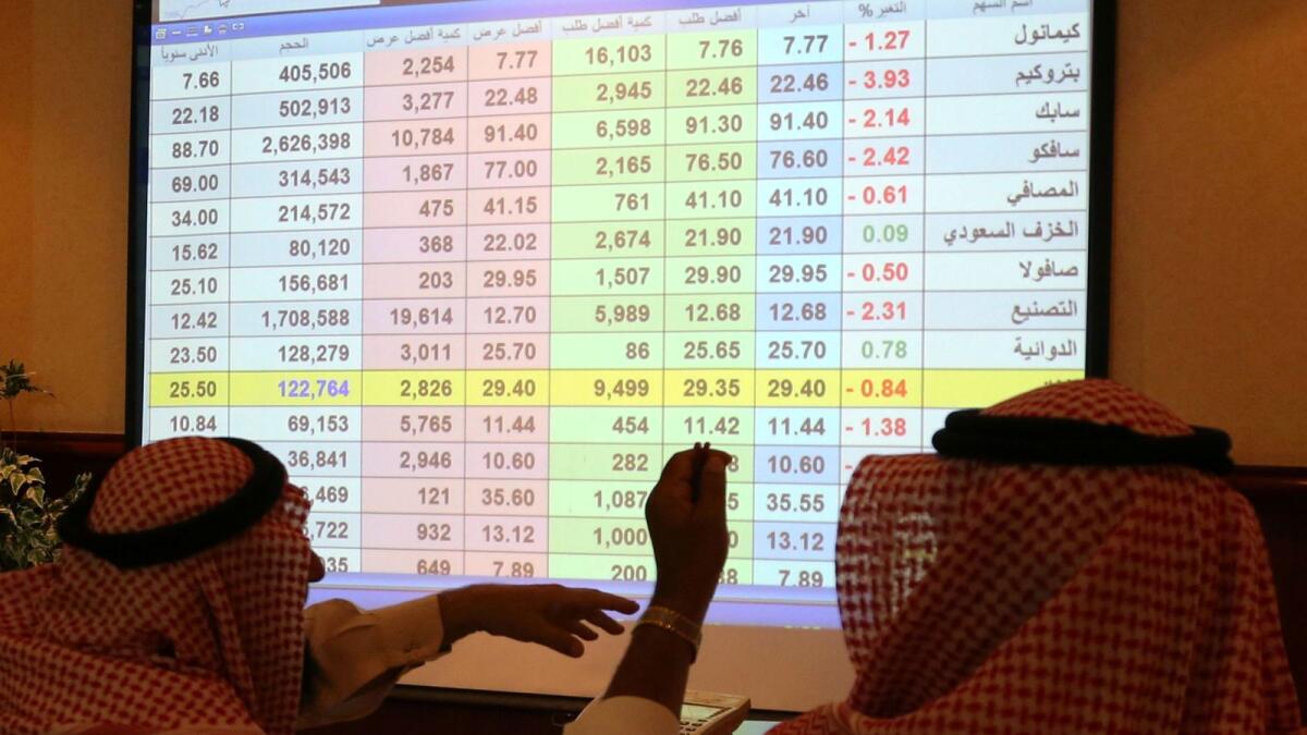 Saudi men look to a screen showing stock prices at ANB Bank, in Riyadh. — Reuters file photo 
