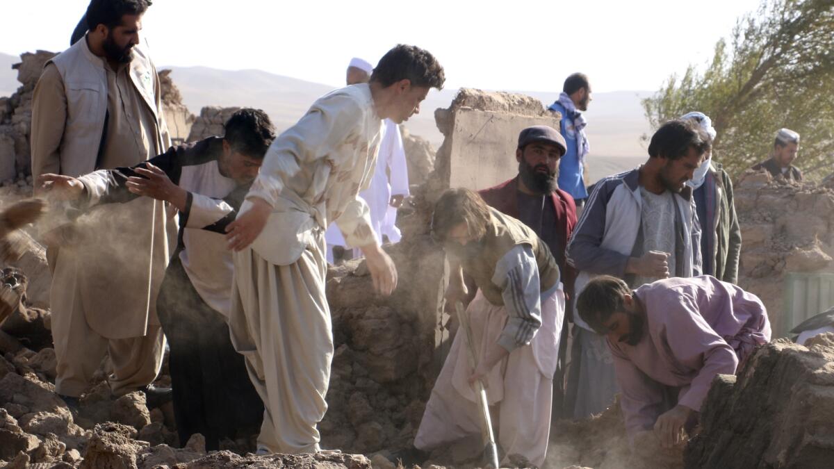 Afghan men search for victims after an earthquake in Zenda Jan district.