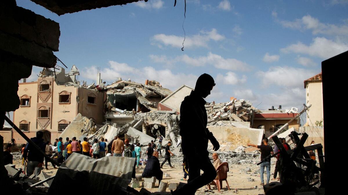 Palestinians inspect the site of an Israeli strike on a house in Rafah. — Reuters