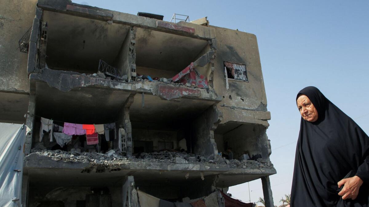 A Palestinian woman walks past a house destroyed by an Israeli strike in Rafah. — Photo: Reuters