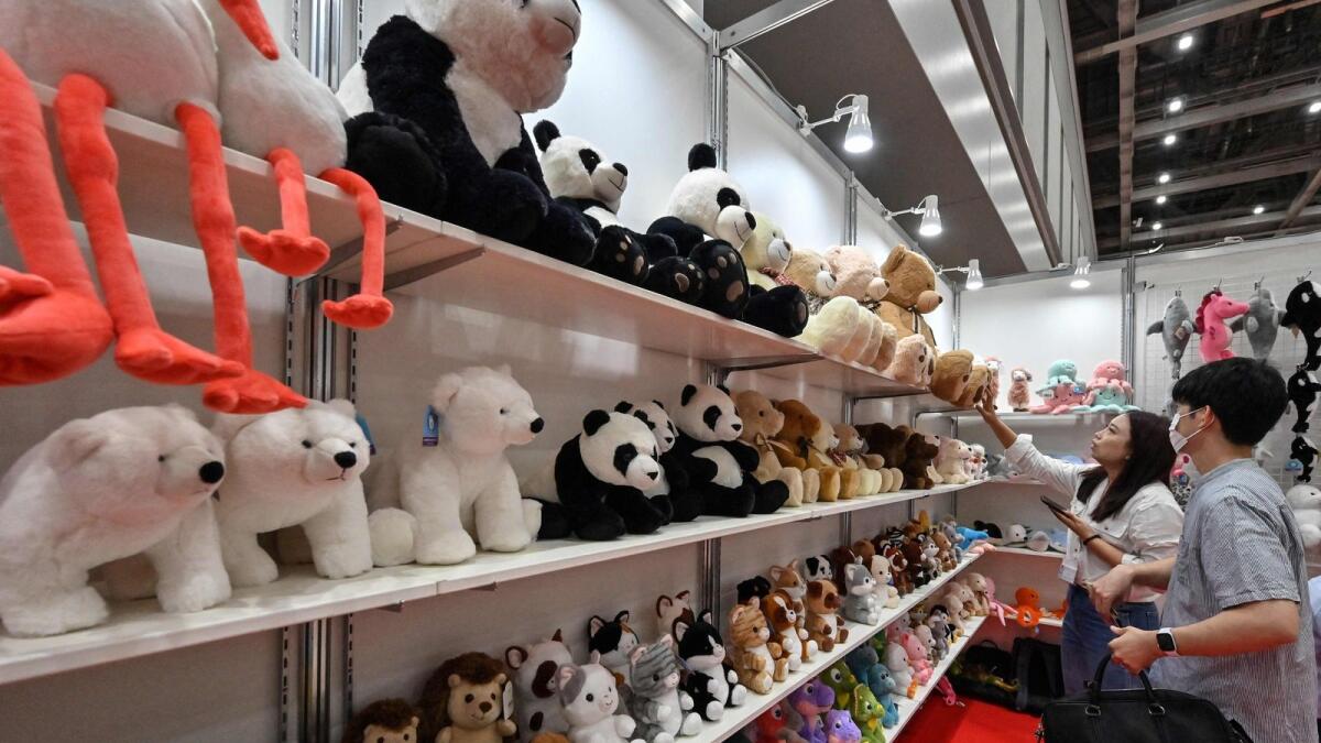 Visitors look at soft toys at a shop. — AFP file