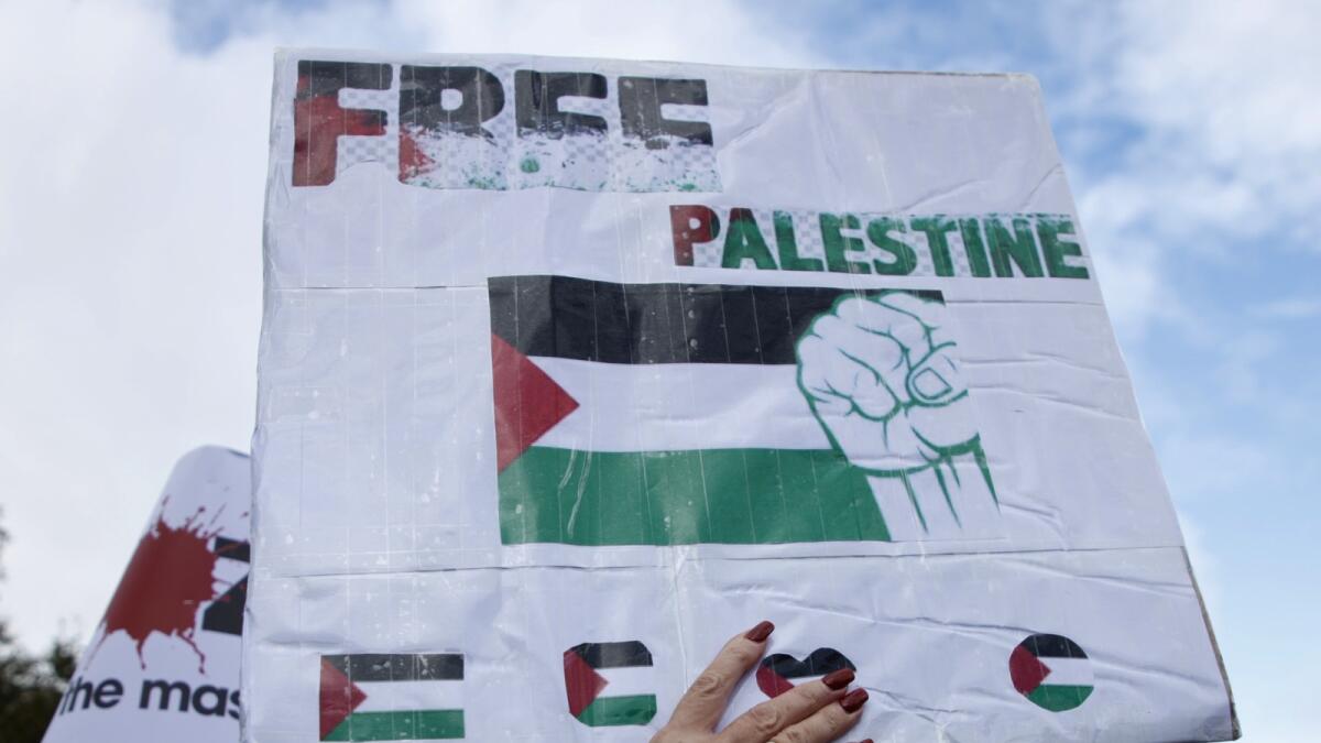 Demonstrators hold up flags and placards during a pro Palestinian demonstration in London. — AP