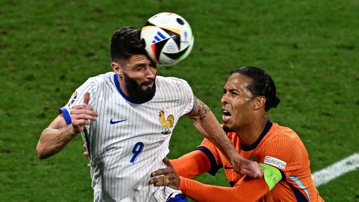 France's forward #09 Olivier Giroud heads the ball past Netherlands' defender #04 Virgil van Dijk during the UEFA Euro 2024 Group D football match between the Netherlands and France at the Leipzig Stadium in Leipzig on June 21, 2024. (Photo by GABRIEL BOUYS / AFP)