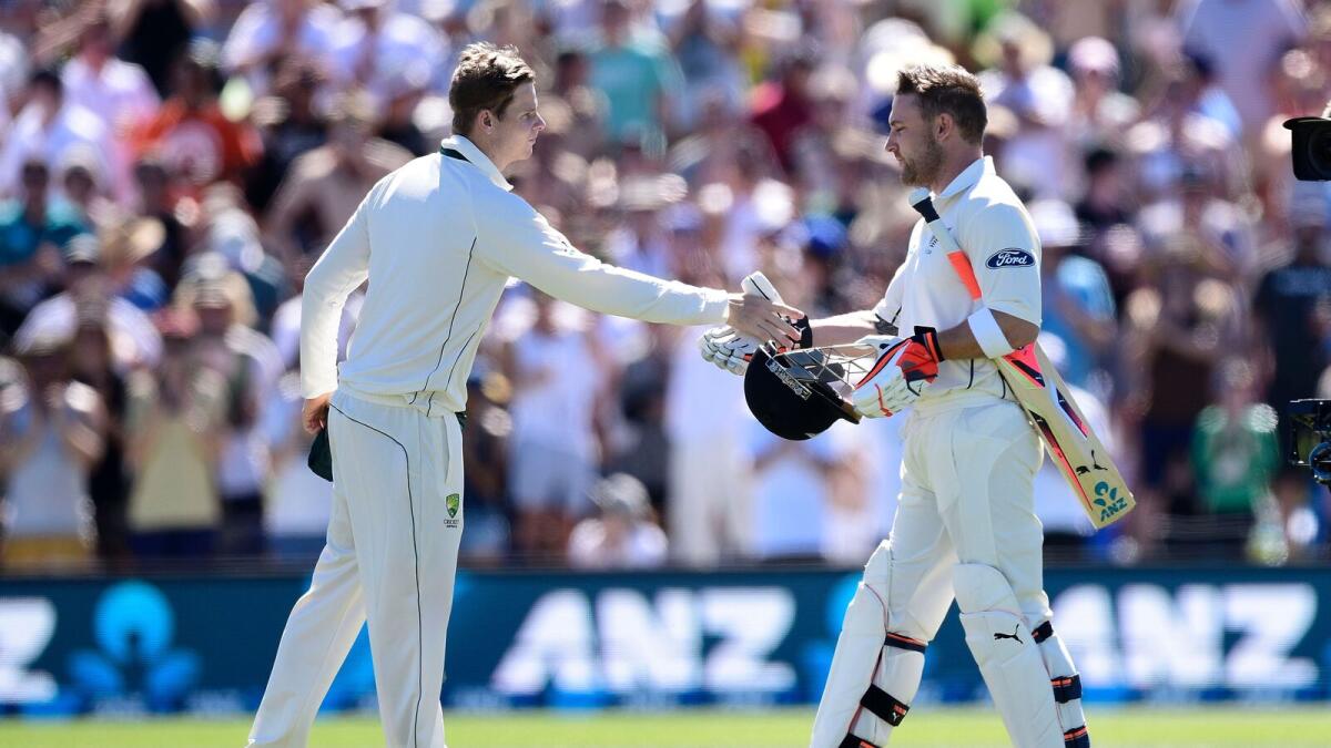 Australia captain Steve Smith (left) shakes hands with Brendon McCullum. (Right) Australian fans applaud McCullum as he walks back to the pavilion after scoring the fastest Test century. — AFP