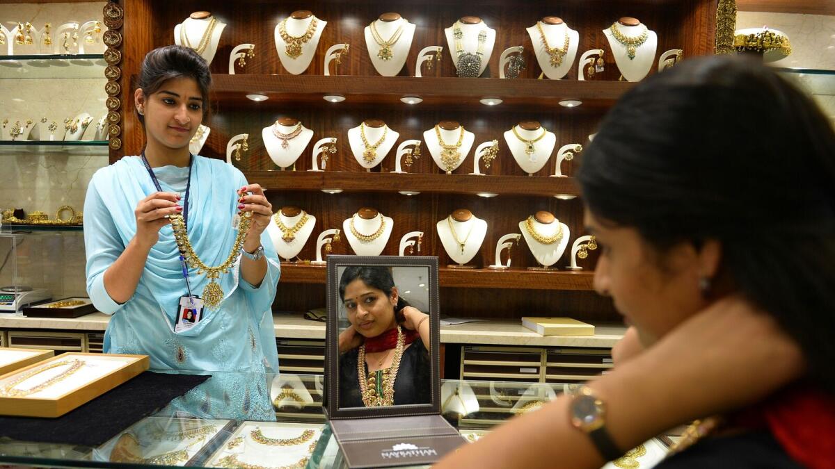 Indian customers buy gold jewellery at a store on the eve of 'Akshay Trititya' in Bangalore on April 20, 2015. AFP PHOTO