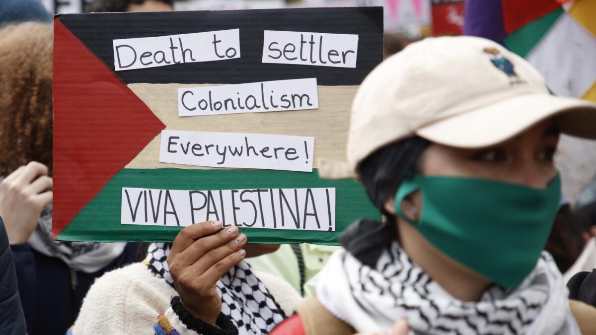 Demonstrators hold up flags and placards during a pro Palestinian demonstration in London. — AP