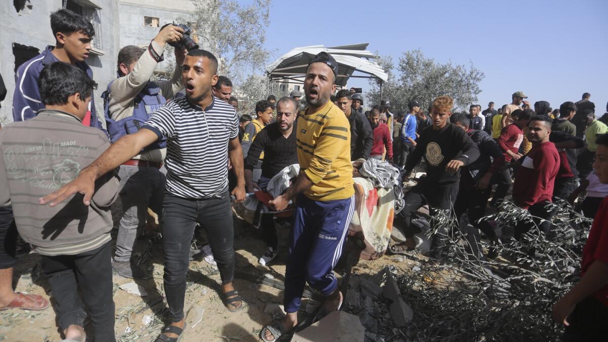 Palestinians evacuate survivors after an Israeli strike on the Gaza Strip in Rafah on Saturday, Nov. 23, 2023. AP