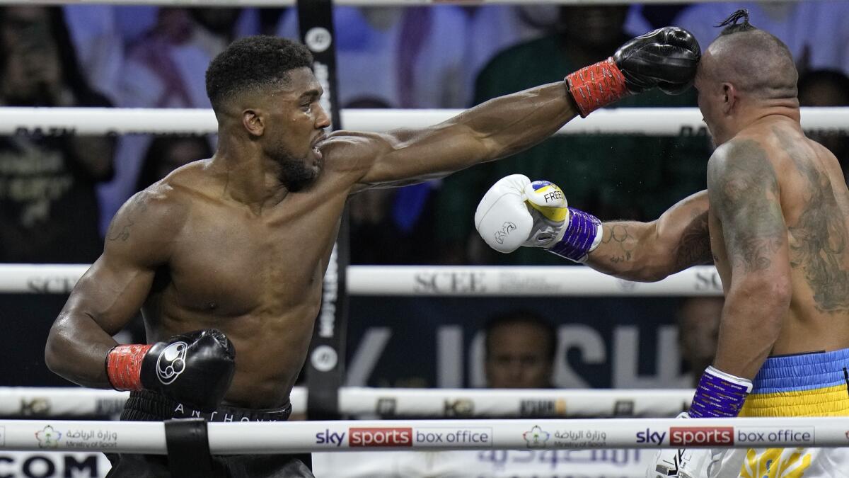 Britain's Anthony Joshua (L), lands a blow on Ukraine's Oleksandr Usyk during their world heavyweight title fight at King Abdullah Sports City in Jeddah, Saudi Arabia on August. 21, 2022.- AP