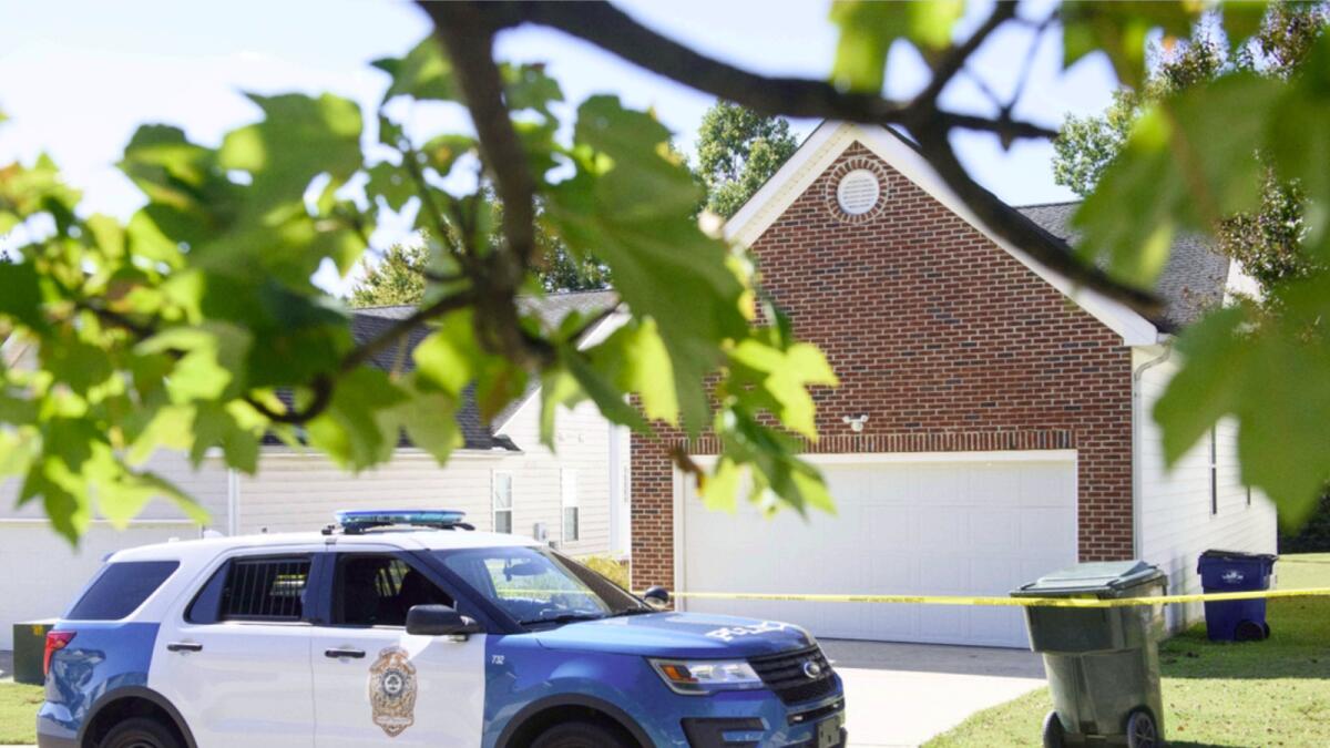 A police officer parks in front of the home of the suspect of a shooting in Raleigh that left 5 dead and 2 injured. — AFP