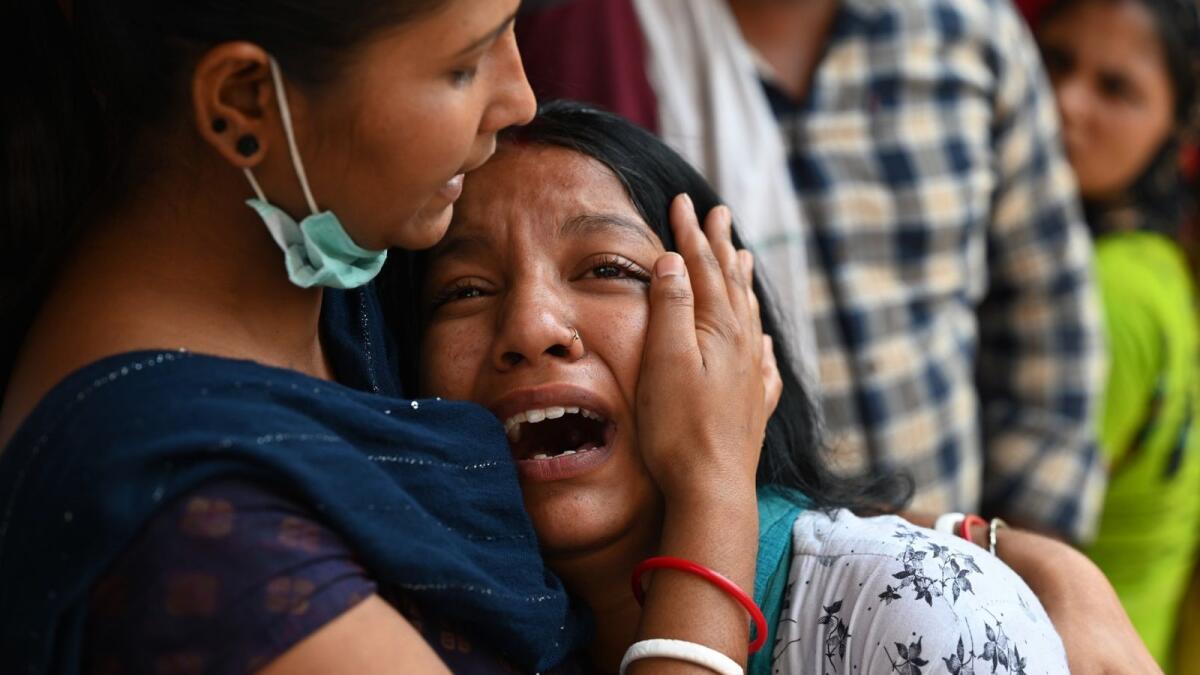 A relative griefs at a hospital as she waits for the body of her loved one a day after a fire broke out at a commercial building, in New Delhi on May 14, 2022. Photo: AFP