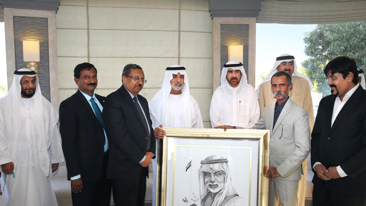 Shaikh Nahyan receives his painting from Akbar Saheb (second from right), as Indian embassy staff and others look on.