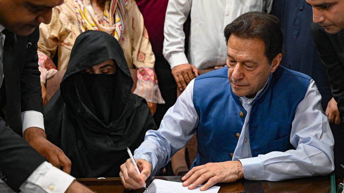Pakistan's former prime minister Imran Khan, along with his wife Bushra Bibi, signs surety bonds for bail in various cases, at a registrar office in the Lahore High Court on July 17, 2023. — AFP FILE
