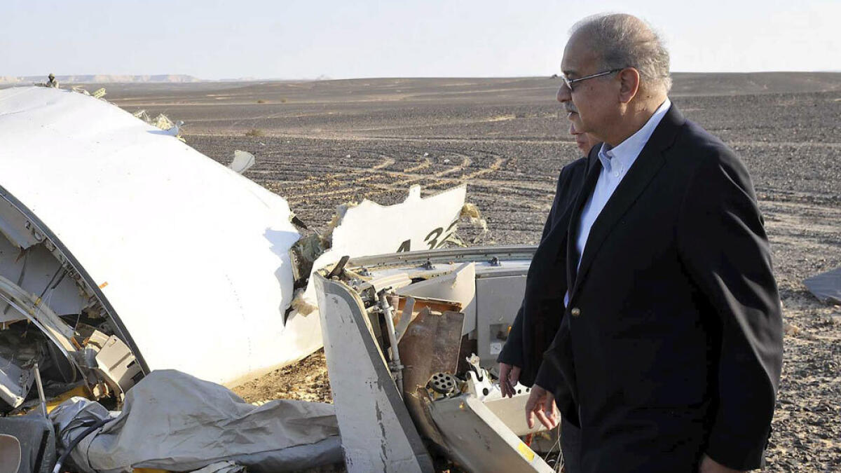 Egypt's Prime Minister Sherif Ismail looks at the remains of the plane crash at the desert in central Sinai near El Arish city.