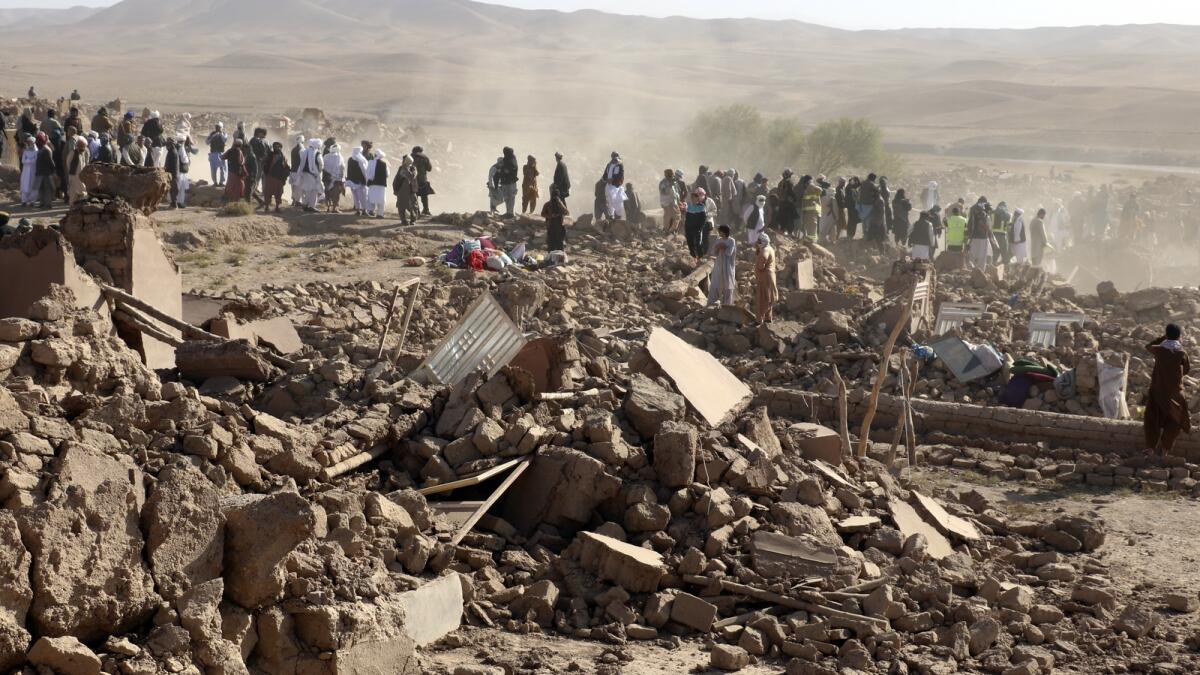 Afghan men search for victims after an earthquake in Zenda Jan district.