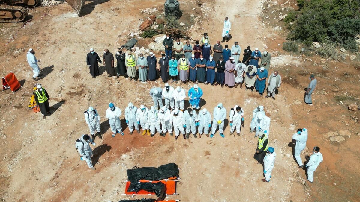 (Photo: Reuters) Volunteers stand beside flood victims as they prepare to hold a funeral prayer at a cemetery in Derna, Libya September 19, 2023.