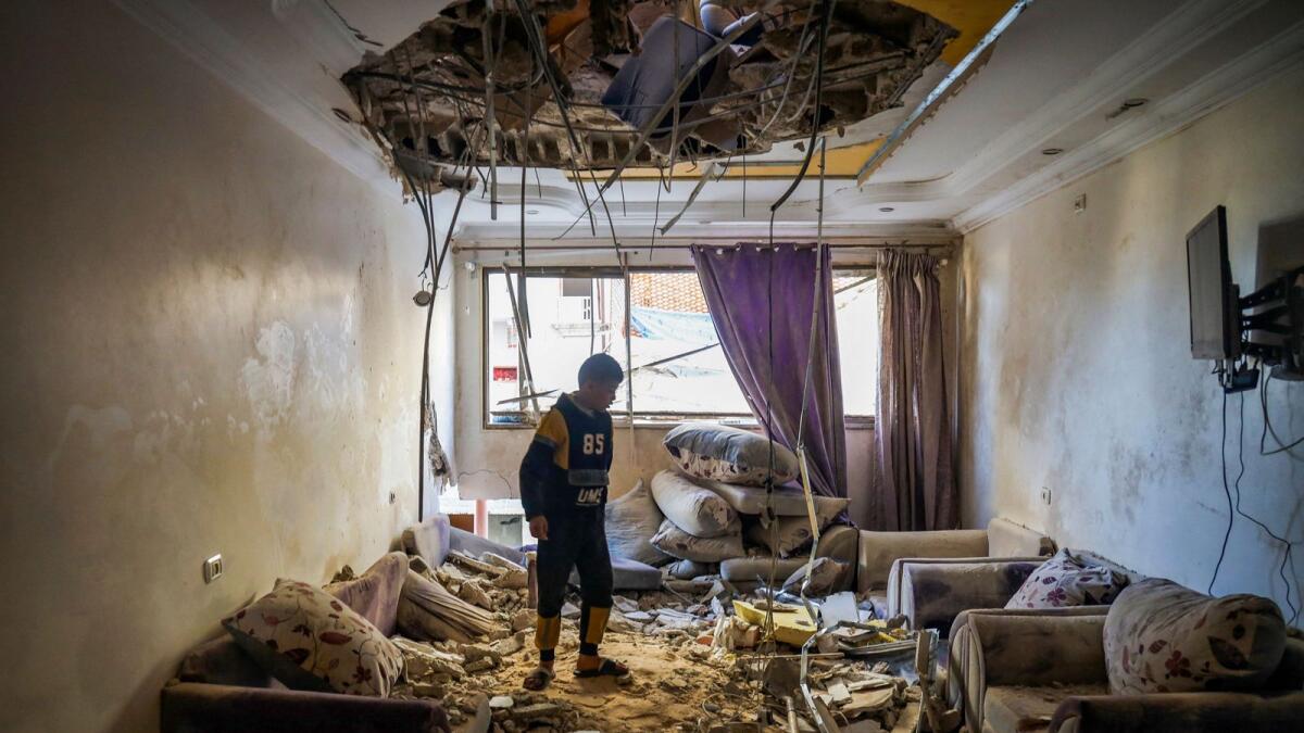 A Palestinian child stands in the living room of a building that was damaged during Israeli bombardment in Rafah. — AFP