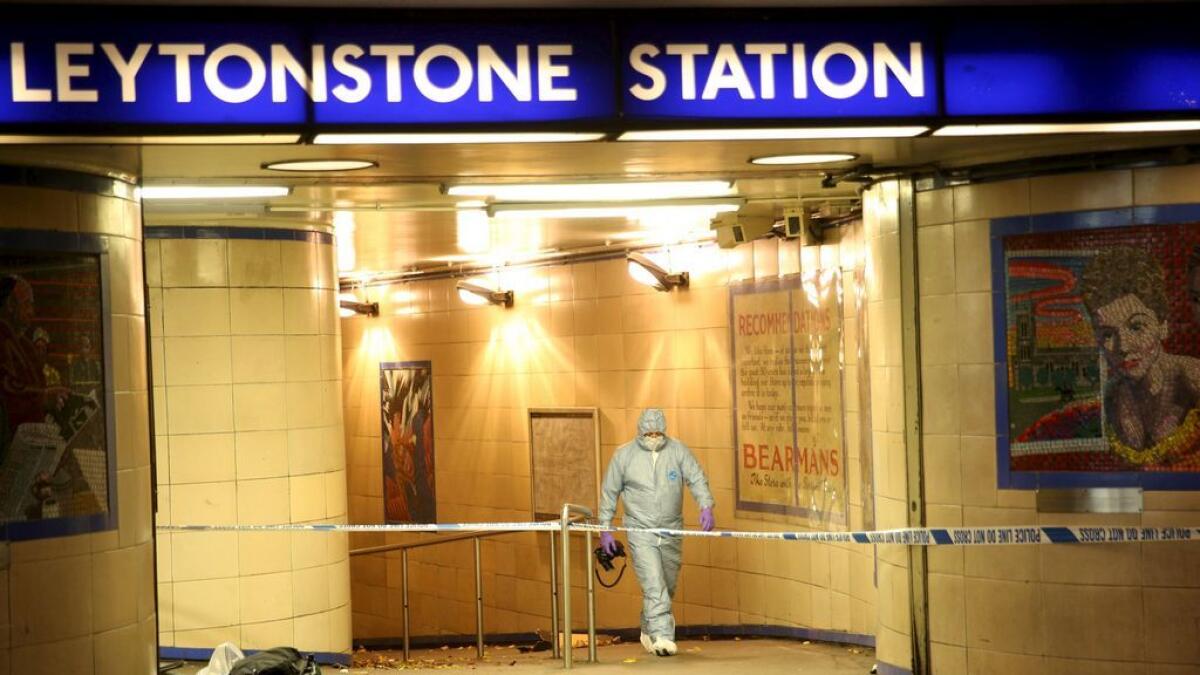 Police officers investigate a crime scene at Leytonstone underground station in east London, Britain.