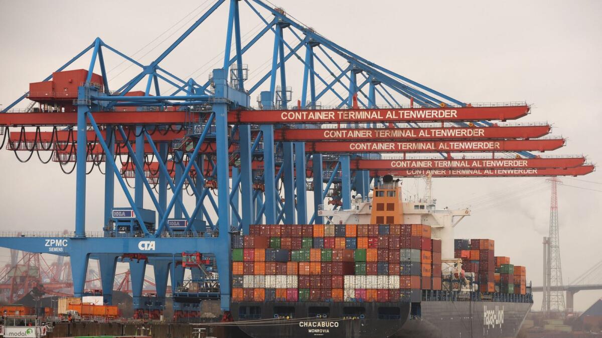 Containers are unloaded at a port in Hamburg, Germany. Global trade growth ticked in at just 2.7  per cent in 2022. - Reuters