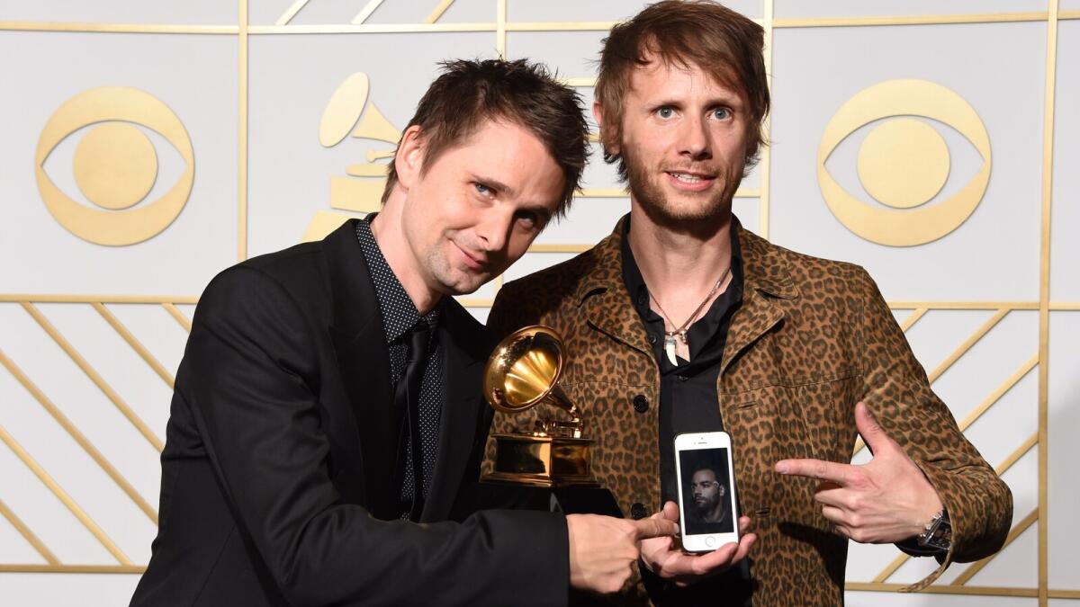 Muse pose in the press room with their Best Rock Album trophy for 'Drone' during the 58th Annual Grammy Music Awards in Los Angeles on February 15, 2016.