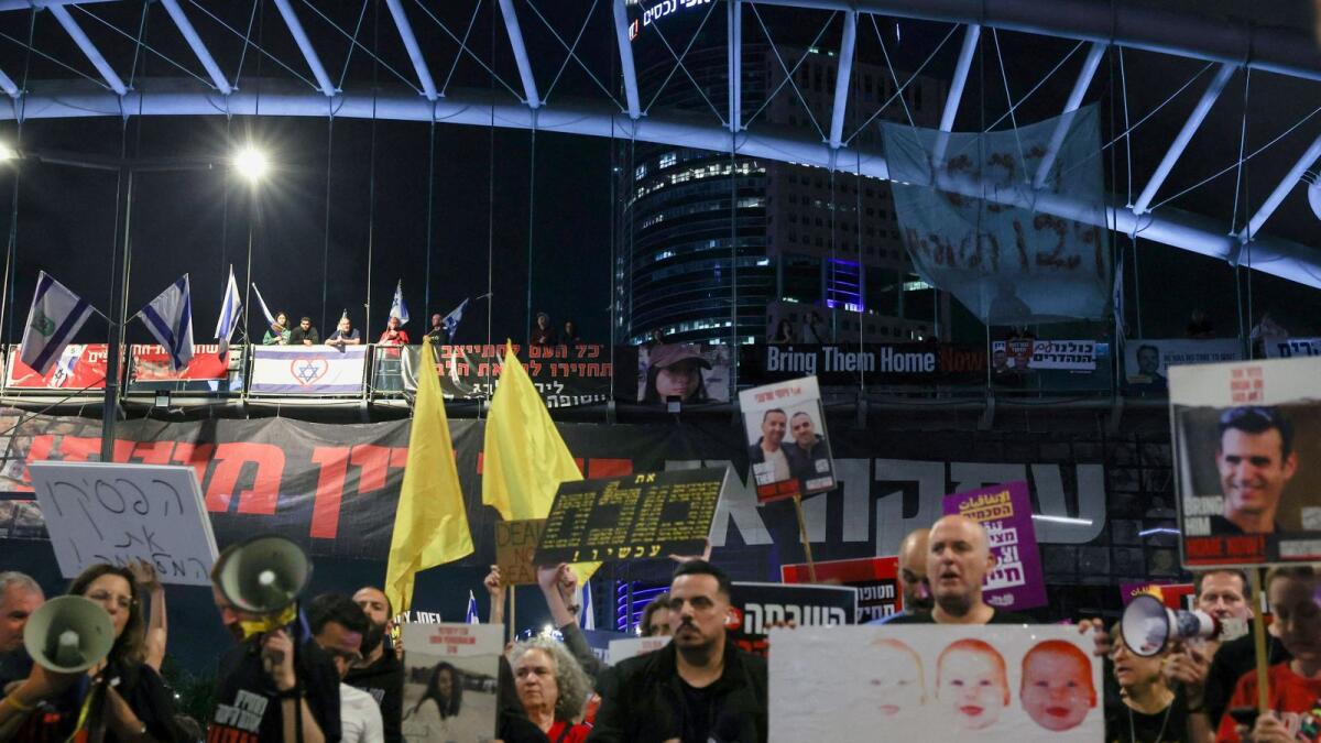 Protesters look at others blocking a highway as they demand the immediate release of Israeli hostages, in Tel Aviv. — Photo: Reuters