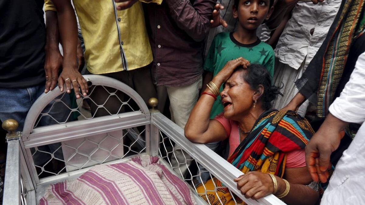 A woman mourns next to the body of Mohammad Ramzani, a cycle rickshaw driver who died after an under-construction flyover collapsed. 