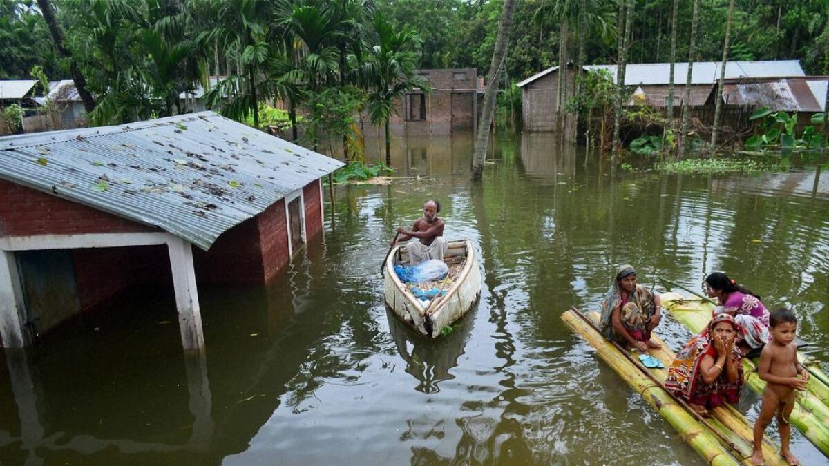 People using makeshift boats to commute in a flood affected village in Bongaigaon district of Assam. 