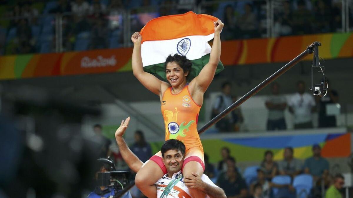 India's Sakshi Malik celebrates after winning against Kirghyzstan's Aisuluu Tynybekova in their women's 58kg freestyle bronze medal match on August 17, 2016, during the wrestling event of the Rio 2016 Olympic Games at the Carioca Arena 2 in Rio de Janeiro.