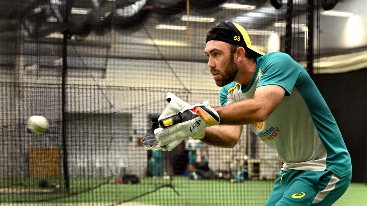 Australian player Glenn Maxwell practices with the wicketkeeping gloves in the nets during a training session in Melbourne on Thursday. — AFP
