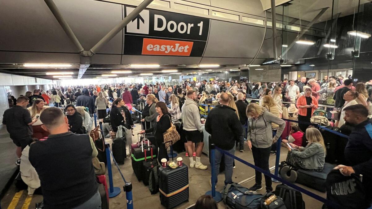 Passengers queue outside Terminal 1 after an overnight power cut led to disruptions and cancellations at Manchester Airport in Manchester, Britain, June 23, 2024. Photo: Reuters