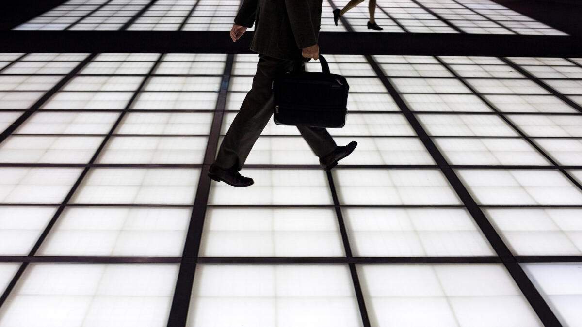 People cross an illuminated floor at a banking district in central Tokyo November 27, 2014. - Reuters