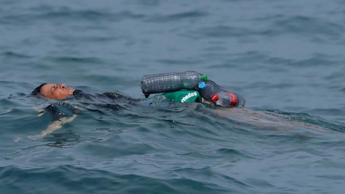 A Moroccan boy swims using bottles as a float, near the fence between the Spanish-Moroccan border. Photo: Reuters