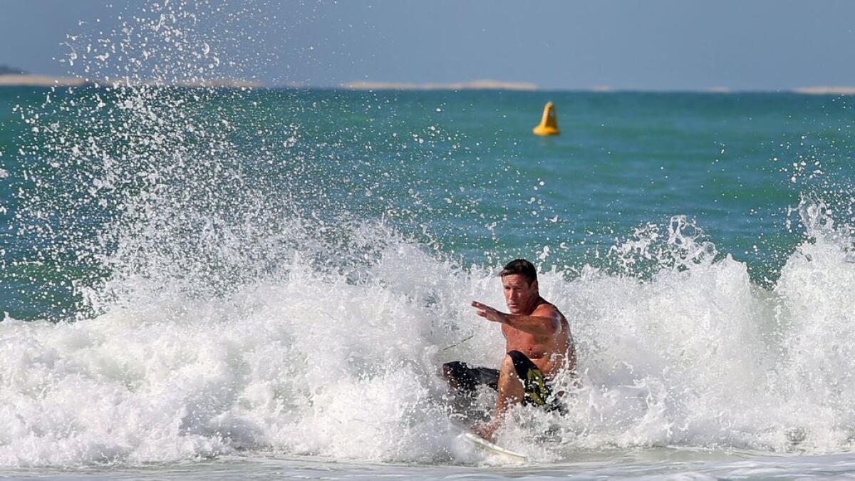 A surfer enjoys a ride on the waves at the Jumeirah Open Beach in Dubai.- Photo by Dhes Handumon/Khaleej Times