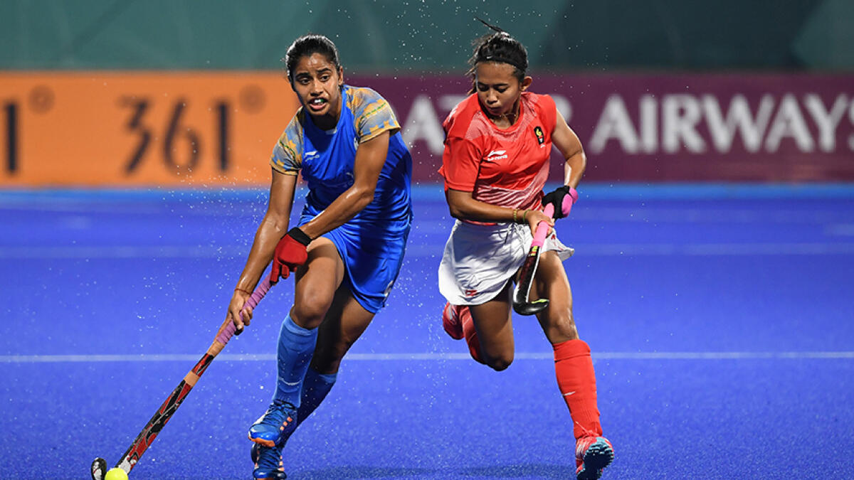 India's Reena Khokhar (left) runs with the ball past Indonesia's Yuanita Suwito during the women's hockey pool B match between India and Indonesia at the 2018 Asian Games. -- AFP file