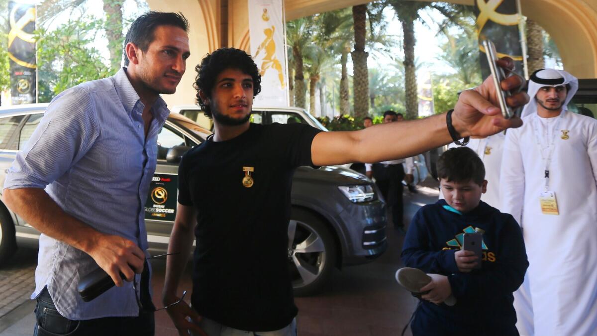 A fan takes a selfie with former England footballer Frank Lampard (left) as he arrives for a Dubai International Sports Conference workshop on Monday.   