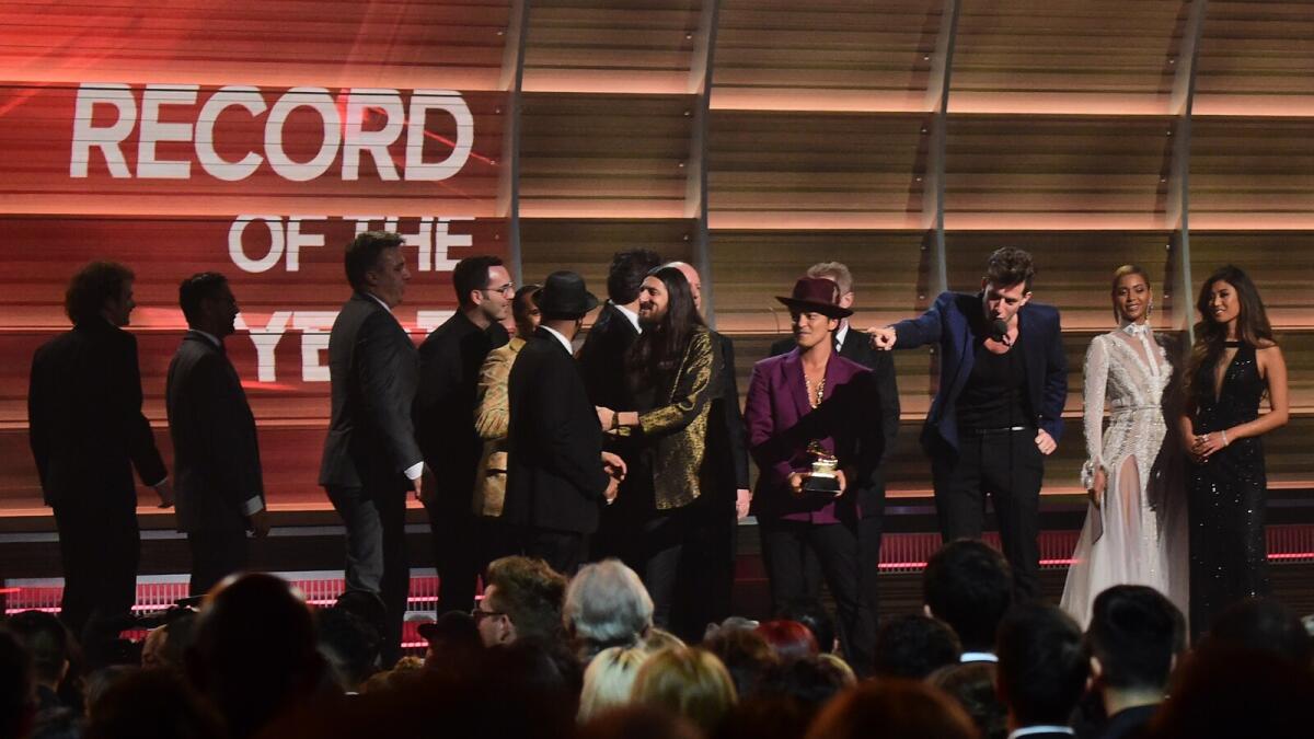 Mark Ronson accepts the award for the Record of the Year, Uptown Funk, as Beyonce (R) and Bruno Mars (C) look on onstage during the 58th Annual Grammy music Awards in Los Angeles February 15, 2016.