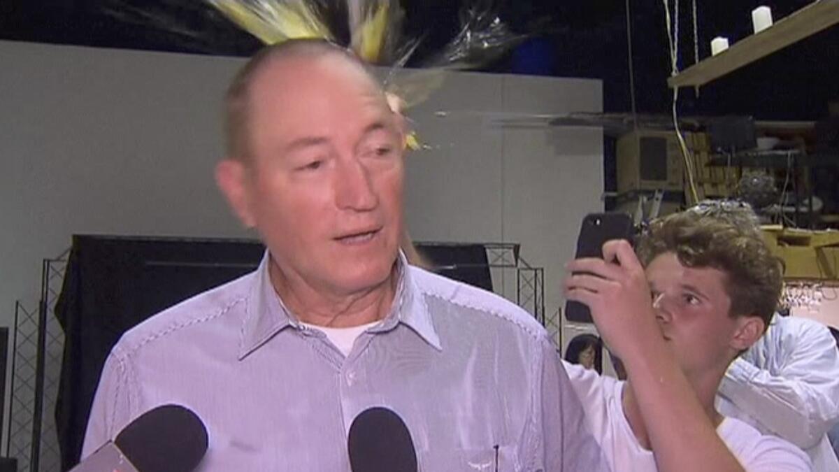 A teenager breaks an egg on the head of Senator Fraser Anning while he holds a press conference, in Melbourne.- AP file photo