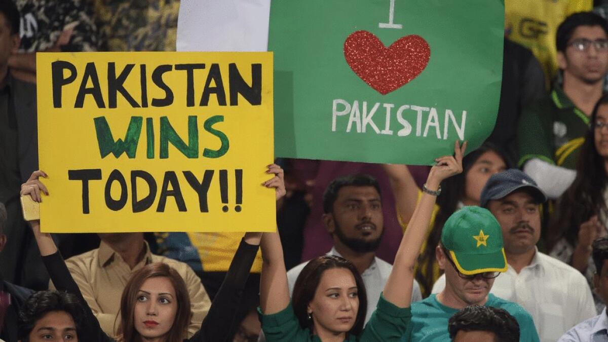 Pakistani spectators hold placards prior to the start of the final cricket match of the Pakistan Super League (PSL) between Quetta Gladiators and Peshawar Zalmi at The Gaddafi Cricket Stadium in Lahore on Sunday.