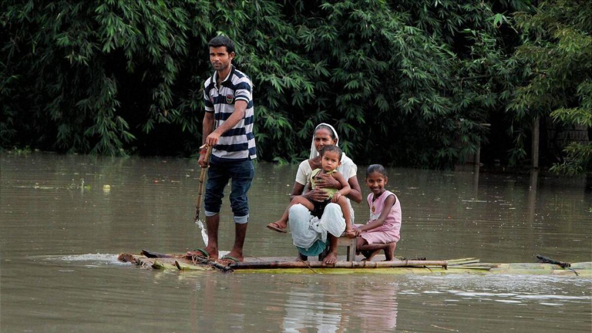 A family uses a banana raft to move at flood-hit Burha Mayong in Morigaon district of Assam. 