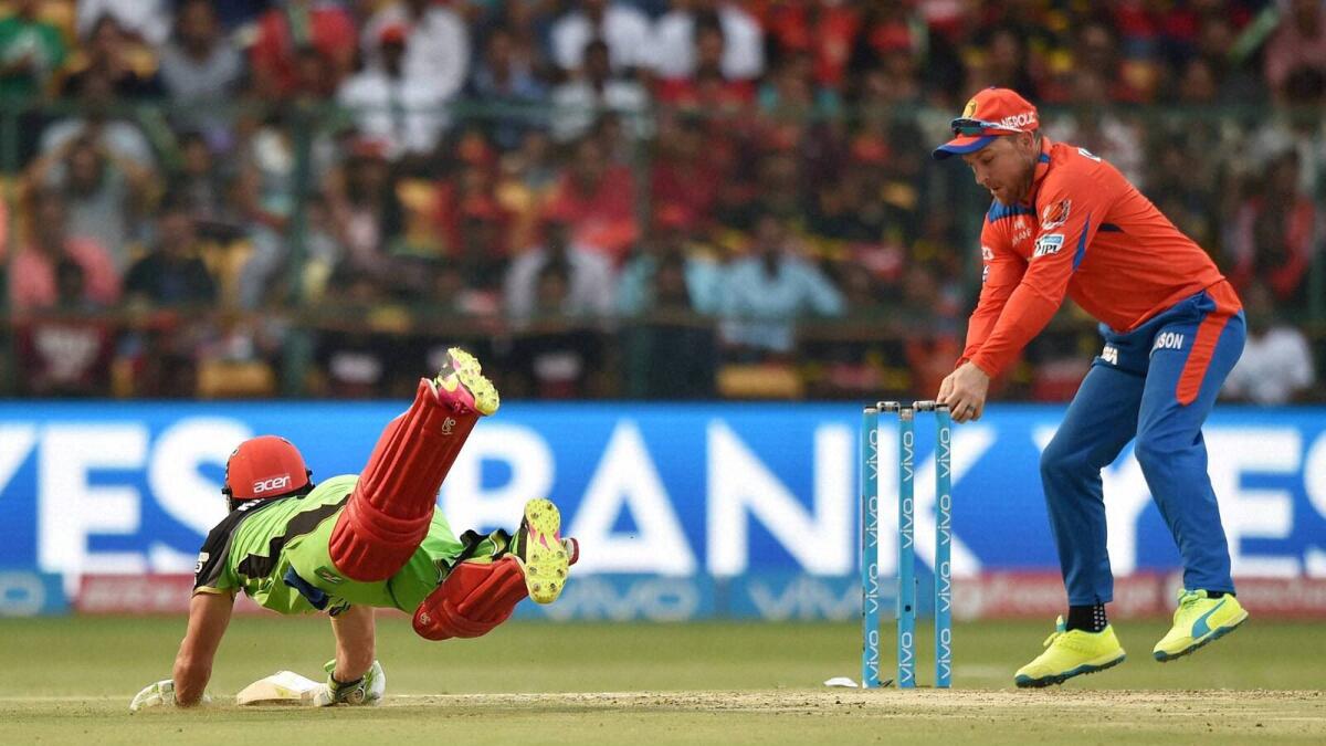 Bengaluru : Royal Challengers Bangalore AB De Villiers dives to reach the crease as Brendon McCullam tries lodge the bails during the IPL T20 match against Gujarat Lions in Bengaluru on Saturday. PTI Photo by Shailendra Bhojak(PTI5_14_2016_000147A)