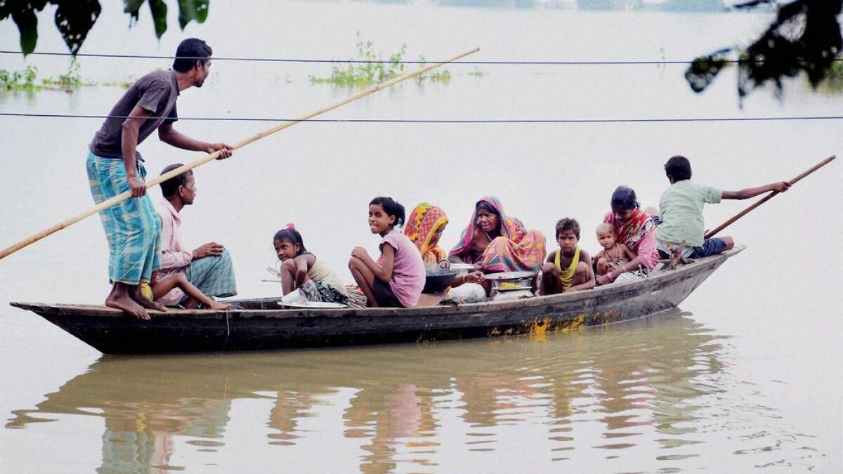 Villagers move to safe place in a boat from the flooded Chandrapur area in Kamrup district of Assam. 