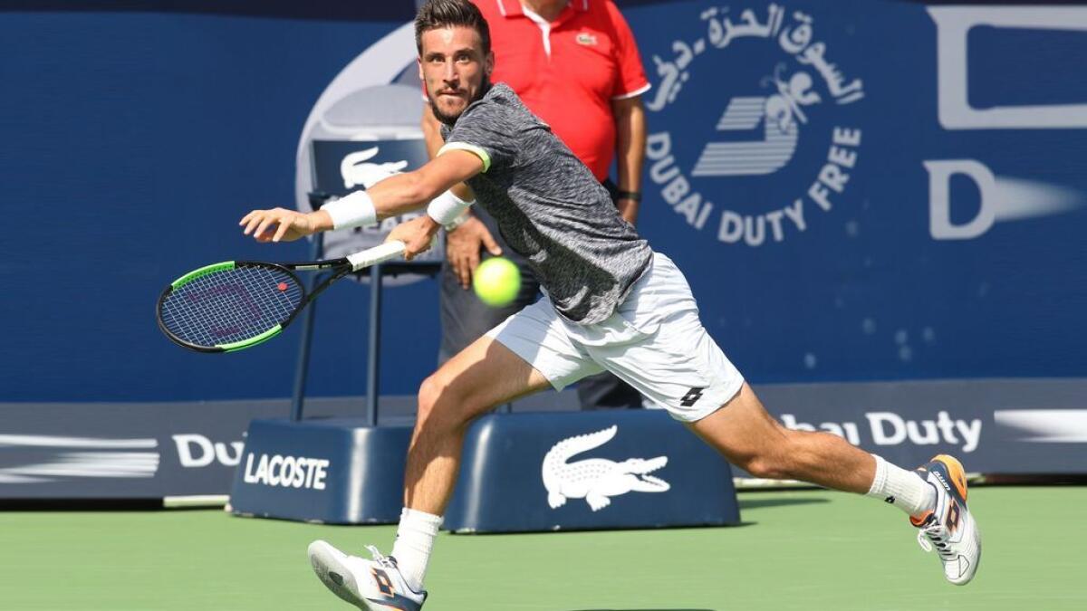 Damir Dzumhur hits a forehand against Stan Wawrinka in the Dubai Duty Free Tennis Championships in Dubai Tennis Stadium on Tuesday,