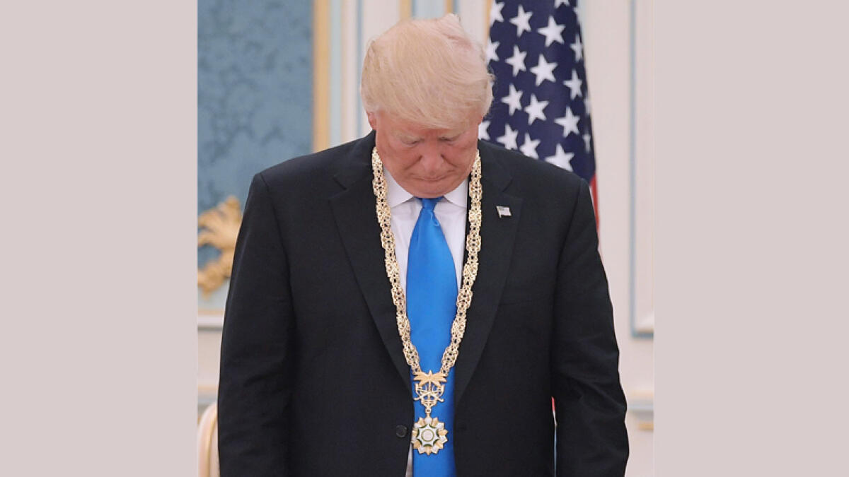 US President Donald Trump looks at the Order of Abdulla al-Saud medal which he received from Saudi Arabia's King Salman bin Abdulaziz al-Saud at the Saudi Royal Court in Riyadh on May 20, 2017.