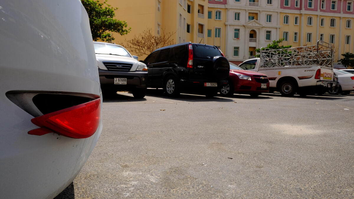 Shortage of parking lots force residents of International City, Dubai, to park their cars in non-designated areas.  Residents say their parked vehicles are being damaged intentionally. —