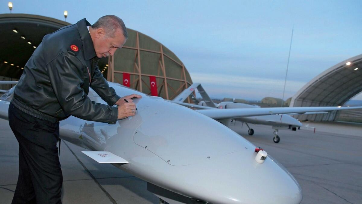 Turkey’s President Recep Tayyip Erdogan signs a drone at a military airbase in Batman, Turkey. — AFP