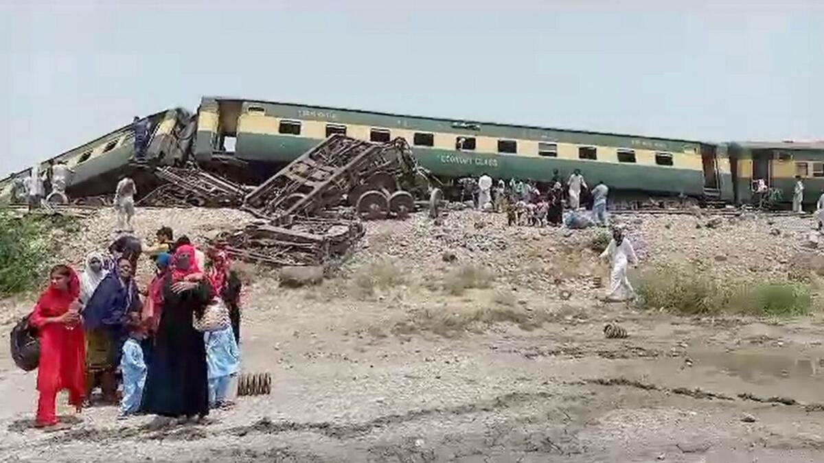 Locals gather at the site where a passenger train derailed near Nawabshah, Pakistan. — PTI