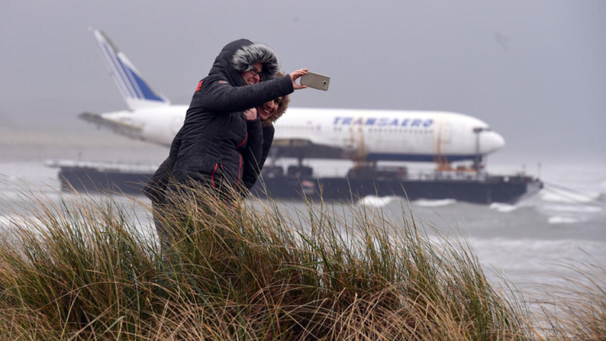 Two women take a picture of a Boeing 767 airplane as it arrived onto Enniscrone beach after it was tugged from Shannon airport out to sea around the west coast of Ireland. - Reuters