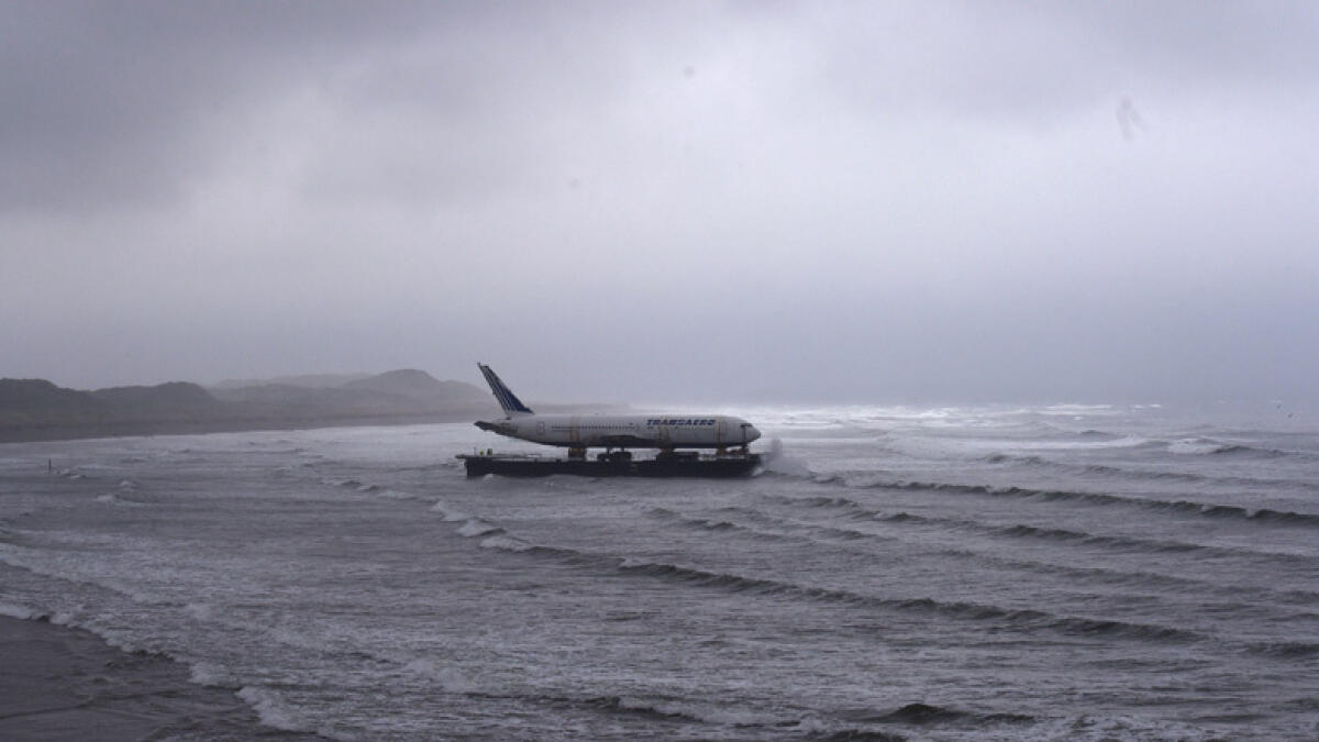 Bad weather surrounds a Boeing 767 airplane as it arrives onto Enniscrone beach after it was tugged from Shannon airport out to sea around the west coast of Ireland, May 7, 2016. - Reuters
