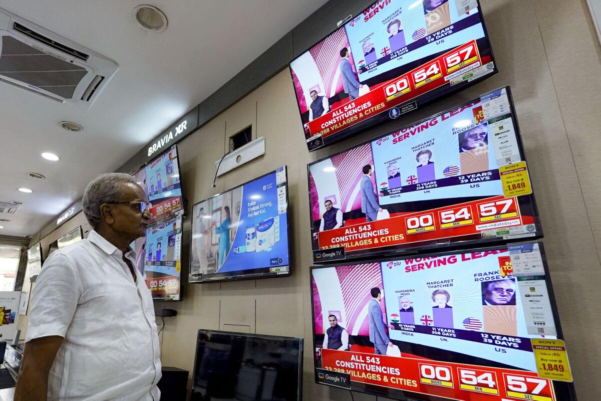 A man watching television waits for the release of exit polls published after voting concludes during its seventh and final phase amid India's general election, at an appliance store in Ajmer on June 1, 2024.  — AFP file