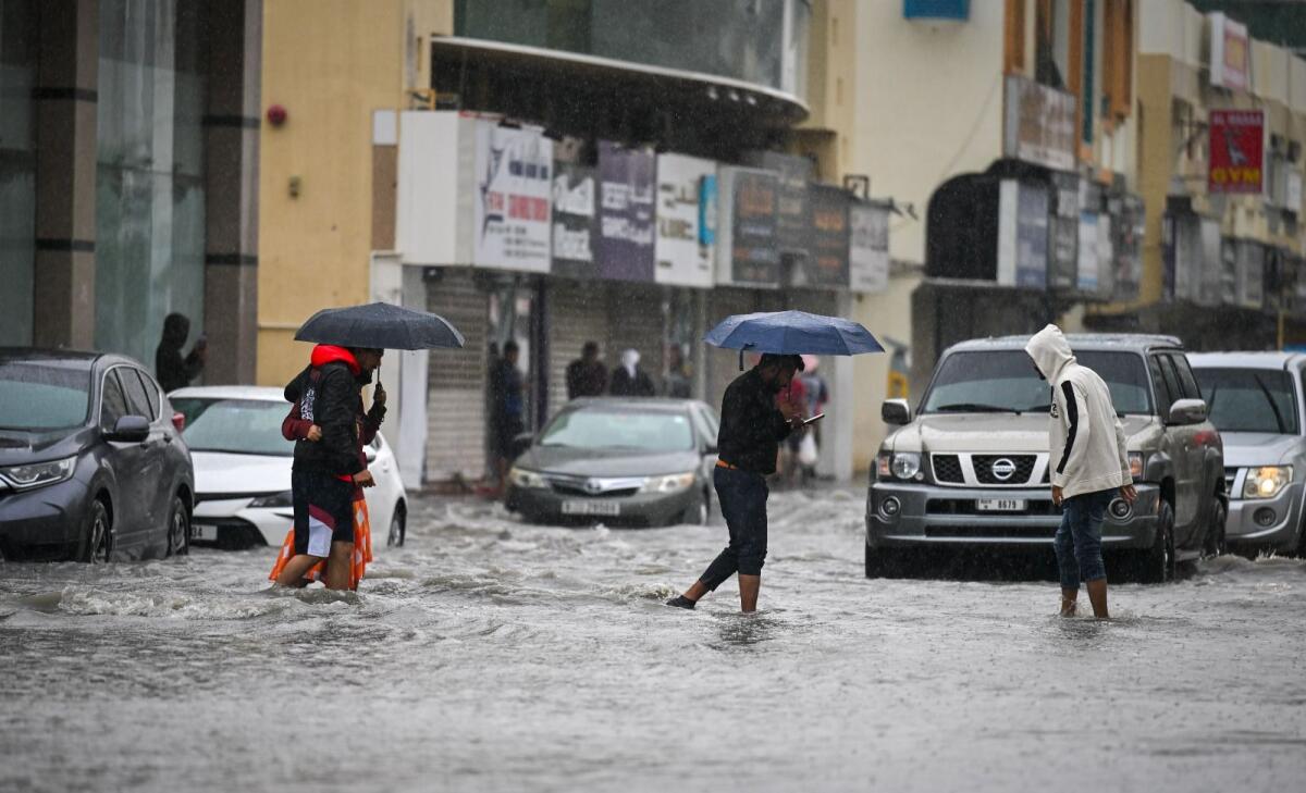FILE. Residents navigate a flooded road in Sharjah as heavy rain hit the area. KT Photo: Muhammad Sajjad