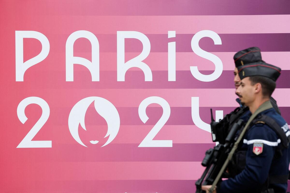 French gendarmes walk past the logo of the Paris 2024 Olympic and Paralympic Games. — Reuters